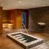 Resort Bad Boekelo indoor spa with square hot tub, sauna benches, and tiled relaxation area in Boekelo