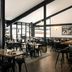 Gravity Haus Steamboat restaurant with stone fireplace, black beams, and dining tables in Steamboat Springs