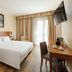 Hotel Dei Cavalieri Caserta room with king bed, desk, wall-mounted TV and balcony doors in Caserta