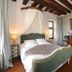 Chateau De Jallanges in Vouvray bedroom with canopy bed, wood beams, dresser and chairs