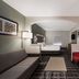 Quality Inn & Suites Irving Dfw Airport South guest room with sofa, desk, beds and red chair in Irving