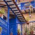 Rumi Wasi in Cusco, blue balconies and hanging potted plants around a stone courtyard