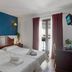 I AM La Posada Hotel and Apartment in Benalmádena bedroom with twin beds, balcony doors, and blue accent wall