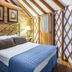 Bluegreen Vacations Shenandoah Crossing in Gordonsville yurt bedroom with wood walls, queen bed, lamp and curtain door