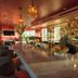 The Eden Santa Monica hotel bar with marble counter, hanging lights and ocean-view palms
