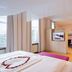 Hotel Haus Delecke room with canopy bed, vanity, seating area and lake view in Möhnesee