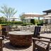Hilton Garden Inn Riverhead patio with fire pit, seating, umbrellas and garden views