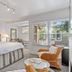 The Upham Hotel Santa Barbara guest room with king bed, wicker chair, and large windows