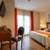 Hotel Valle de Cabezón guest room with double bed, desk, chair and balcony doors in Cabezón de la Sal