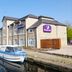Premier Inn Huddersfield Central by canal with moored boat in Huddersfield