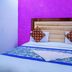 Hotel Ashoka Palace Near Igi Airport room with bed, purple accent wall, and blue bed runner in New Delhi