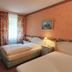 Wald-Hotel Troisdorf room with twin beds, desk, TV, and floral curtains