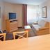 Candlewood Suites Junction City Fort Riley room with sofa, TV, dining table and bedroom view in Junction City