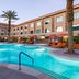 Cannery Casino Hotel in North Las Vegas with outdoor pool, palm trees, and orange lounge chairs
