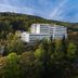 Hotel Behounek in Jáchymov set on a wooded hillside beneath a green mountain