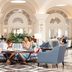 The Phoenicia Malta in Valletta lobby lounge with blue armchairs, marble floors, and arched windows