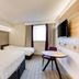 Purple Roomz Preston South hotel room in Preston with two beds, wall-mounted TV and round table
