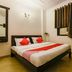 Amrit Villa New Delhi bedroom with double bed, red accents, wall mirror and curtained window