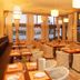 Karystion Hotel in Kárystos restaurant with set tables and sea-view windows at sunset