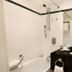 Hanoi Crystal Hotel bathroom with bathtub, walk-in shower, black vanity and mirror in Hanoi
