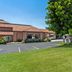Days Inn by Wyndham Fontana / Rialto in Rialto exterior with lawn, trees and parking lot