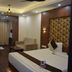 Hotel Apple Valley in Kodaikanal guest room with king bed, sofa, desk and mirrored wardrobe