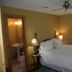 Emilyville Inn in Campbellford guest room with white bed, bedside lamps, ceiling fan, and ensuite bathroom door
