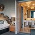 Althoff Grandhotel Schloss Bensberg bedroom with ornate bed and adjoining marble bathroom in Bergisch Gladbach