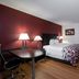Red Roof Inn Warrenton guest room with king bed, desk, chairs, and wood flooring in Warrenton
