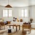 Le Moulin, Lourmarin: bright lounge with white shutters, wicker chairs, and curved built-in seating