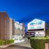 The Wellington Apartment Hotel in Brisbane exterior with illuminated facade and vacancy sign at dusk