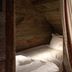 Cotswold Plough Hotel & Restaurant in Bampton, rustic wood-paneled bed nook with curtain and desk