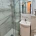 Villa Montmartre - Nouvellement Rénové in Paris bathroom with glass shower, sink and marble-look walls