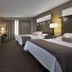 Palace Casino Resort Biloxi guest room with two double beds, desk, and large window with curtains