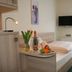 Sonnenhof Bad Wildbad guest room with bed, TV, fruit tray, flowers and balcony light