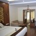 Hotel Apple Valley, Kodaikanal room with bed, sofa, desk, wood paneling and wall-mounted TV