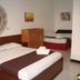 Azzurro Di Boracay Resort room with two beds, wall art, and tiled floor in Boracay.