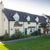 Purple Roomz Preston South (Cuerden Way) in Preston, exterior of a cream hotel with green lawn