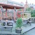 The Manor House Hotel in Dronfield: outdoor patio with picnic tables and wooden pergola beside stone wall