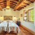 Agriturismo Palazzi del Papa in Pienza: twin beds in a rustic room with exposed wooden beams and open windows
