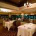 Sheraton Pilar Hotel & Convention Center in Pilar dining room with white-clothed tables and city views at night