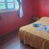 Hosteria Ailen in Ushuaia room with double bed, red walls, and window light