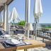 Dining area at Domaine De La Corniche in Rolleboise with floor-to-ceiling windows and scenic terrace views