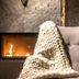 Silverton in Białka Tatrzańska: cozy lounge chair beside a lit fireplace with a chunky knit throw