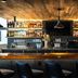 Gravity Haus Steamboat bar with shelves of spirits and black bar stools in Steamboat Springs