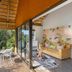 The Cavern in Bonjaneni with a thatched balcony overlooking lush greenery and indoor seating area