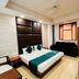 Amrit Villa New Delhi guest room with double bed, sofa, and wardrobe