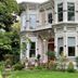 Mccall House Boutique Inn in Ashland, Victorian-style hotel exterior with red entrance and garden landscaping