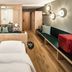 Falkensteiner Hotel Antholz adults-only room with bed, wood accents, seating bench and modern lighting in Rasun Anterselva
