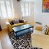 Chateau De Montreuil in Montreuil living room with yellow sofas, coffee table, patterned rug and bright windows